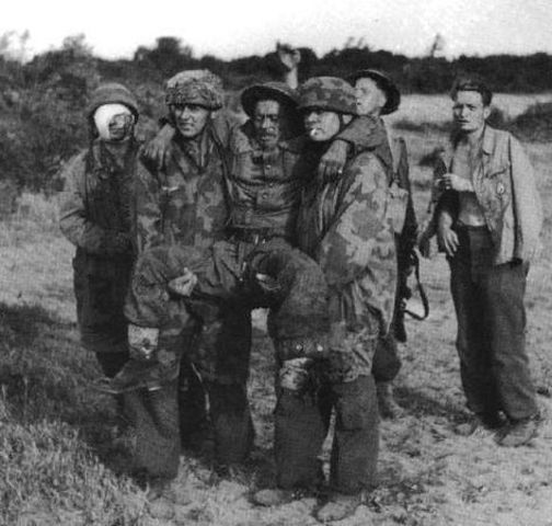 Fallschirmjägers capturados transportando a un soldado británico herido por una mina anti persona